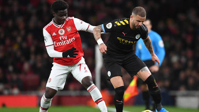 LONDON, ENGLAND - DECEMBER 15: Bukayo Saka of Arsenal takes on Kyle Walker of Man CIty during the Premier League match between Arsenal FC and Manchester City at Emirates Stadium on December 15, 2019 in London, United Kingdom. (Photo by Stuart MacFarlane/Arsenal FC via Getty Images)